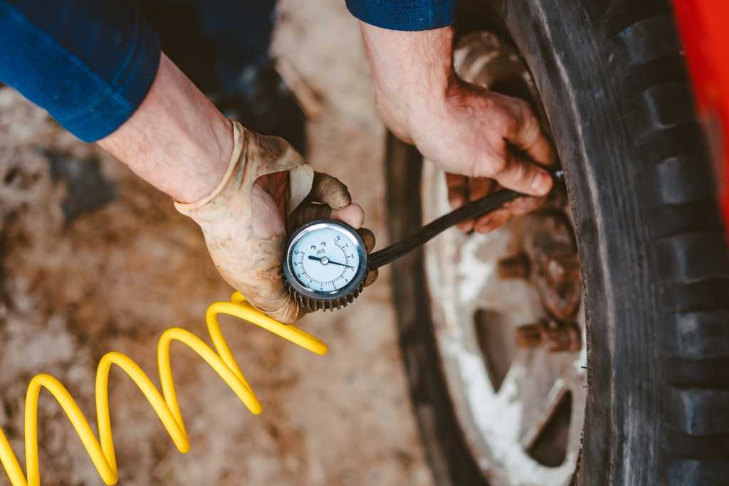 man pumps air wheel with compressor